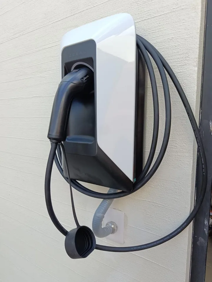Cargador de pared instalado, con su conector y cable recogido