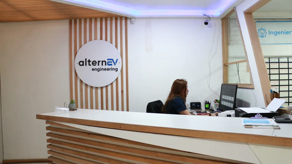 Recepción de AlternEV con el letrero de la empresa y una integrante del equipo en el mostrador
